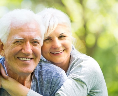 Older couple smiling with dentures